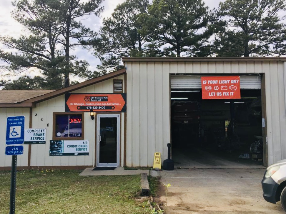 The front of J&T Truck and Auto Service at 800 Rock Quarry Rd, Stockbridge, GA, with the service bay open